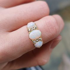 A beautiful antique ring, set with three oval-shaped cabochon opals, with a total of six old-cut diamonds set in-between, mounted in 18ct yellow gold, in a classic carved claw setting. With British hallmarks dating the ring to 1906. Hallmarked as 18ct gold, dated Birmingham 1906. The approximate weight is 4.6 grams. Please note the antique ring box pictured is for display purposes only. Thank you. Ring size K (UK) or 5 1/8 (US) - this ring can be adjusted in size in our workshop. Please get in touch to discuss sizing options and lead time. For UK to US ring size conversions we use www.ringsizes.co as our reference chart. CONDITION: In overall very good antique condition, with some light wear commensurate with age. LAYAWAY: We happily offer layaway/deposits on the majority of our items. Ple