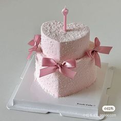 there is a pink cake with a candle on it