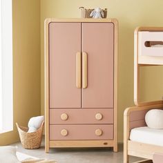 a child's bedroom with two bunk beds and a pink cabinet