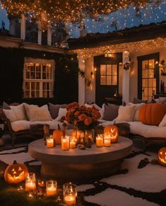 a patio with pumpkins and candles lit up on the ground in front of it