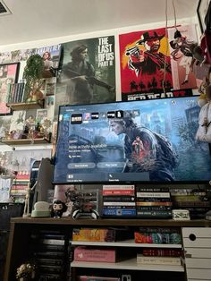 a large flat screen tv sitting on top of a wooden shelf next to a bookshelf