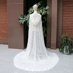 a white wedding gown on display in front of a brick building