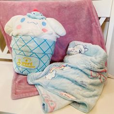 two baby blankets and a stuffed animal on a pink chair next to a teddy bear