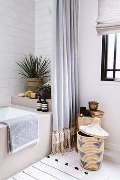 a bathroom with a tub, shower curtain and plants in the bathtub next to it