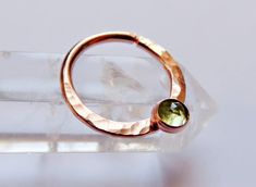 This peridot septum ring is handmade by me with rose gold filled hard wire and hammered for texture (gold filled wire is different than gold plated in that the plating is much thicker and the plating will never rub off. with proper care it will last as long as real gold).  Soldered onto the ring is a 3mm rose gold filled setting with a 3mm peridot stone set inside of it. The ring is available in 16, 18, and 20 gauge and you can also choice between 10mm and 8mm for the diameter. *NOTE* To open ri Daith Ring, Gauges Piercing, Opal Septum, Daith Rings, Helix Ring, Cartilage Ring, Daith Earrings, Septum Jewelry, Peridot Stone