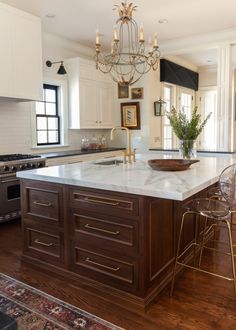 a large kitchen with an island in the middle and chairs at the counter top,