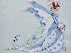 a cross stitched picture of a woman with flowers on her dress