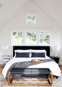 a bedroom with a large bed and white walls