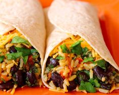 two burritos with black beans, cheese and cilantro on an orange plate