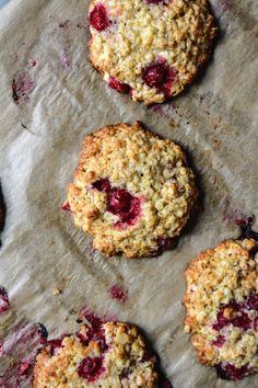 four berry crumbled cookies sitting on top of a piece of waxed paper