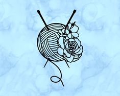 a ball of yarn with a rose on it and two knitting needles in the foreground