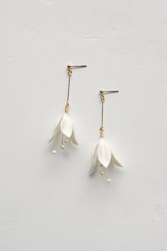 two white flowers are hanging from hooks on the earwires, with pearls attached to them