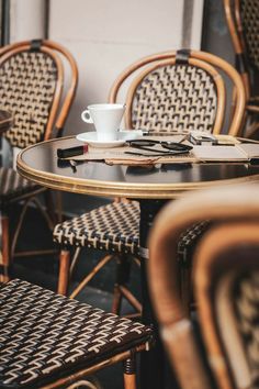 there is a cup and saucer on the table with some napkins next to it