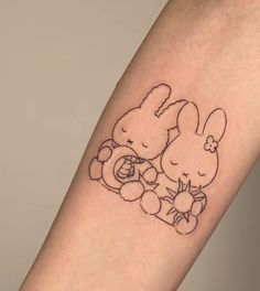 a tattoo on the arm of a person with a small bunny holding a teddy bear