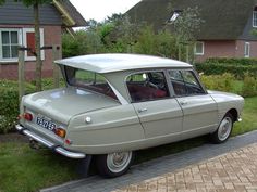 an old car is parked in front of a house