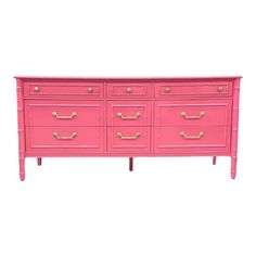 a pink dresser with gold handles on it's sides and drawers, against a white background