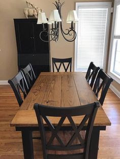 a dining room table and chairs in front of a window