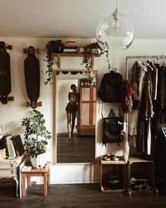 a woman standing in front of a mirror next to a shelf with shoes on it