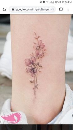 a small flower tattoo on the side of a woman's lower back ribcage