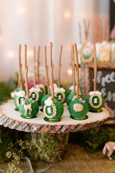 there are green desserts on the table with sticks sticking out of it's top