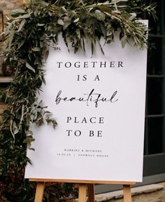 a sign that says together is a beautiful place to be with greenery around it