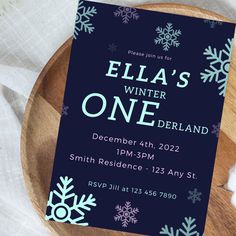 a blue and white snowflaked birthday party card on a wooden platter