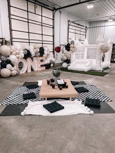 a table with black and white checkered cloths on it, surrounded by balloons