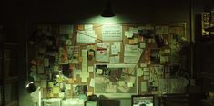 a room with many papers on the wall and lights in the ceiling above it at night