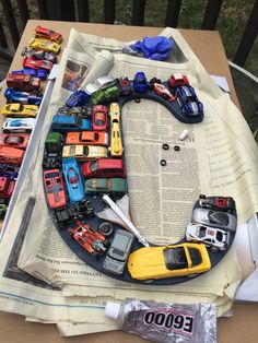 toy cars are arranged on top of an open newspaper