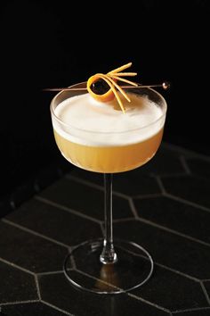 a cocktail with an orange garnish on the rim