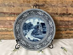 a blue and white plate sitting on top of a table next to a wooden wall