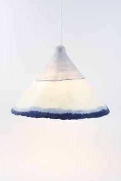 a white and blue lamp hanging from a ceiling