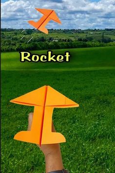 someone is holding an orange paper airplane in their hand with the word rocket above it