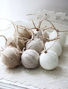 some ornaments are sitting on a doily with burlap and twine around them