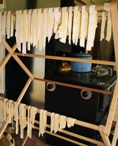 a kitchen area with a stove, oven and wooden ladders that have tassels hanging from them