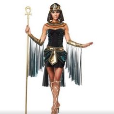 an egyptian woman dressed in costume and holding a staff