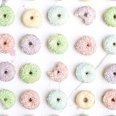 there are many donuts with different colors and designs on the doughnuts is white