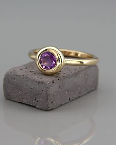 ✿ DESCRIPTION A handmade solid 14k gold ring set with a natural Amethyst. A delicate and graceful ring, carefully crafted from 14k solid  gold and set with a natural Amethyst gem. The stone bezel  designed as a ball, emphasizing the stone color and  The gentle satin finish gives the ring a luxurious royal look. THE RING Made from solid 14k gold, 2mm half-round wire. The ring in the  photos has satin matte finish. A high polished finish is also available.  The ring in the photos made from yellow Timeless Yellow Gold Amethyst Ring, Minimalist 14k Gold Amethyst Ring, Yellow Gold Solitaire Amethyst Ring, Purple 14k Gold Amethyst Bezel Setting Ring, Yellow Gold Amethyst Ring With Bezel Setting, Timeless 14k Gold Amethyst Ring, Timeless Amethyst 14k Gold Ring, 14k Gold Purple Amethyst Ring With Bezel Setting, Yellow Gold Amethyst Ring With Bezel Setting Gift