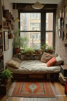 a living room filled with lots of plants and furniture next to a large window covered in bookshelves