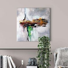 an abstract painting hangs on the wall above a chair and bookshelf in a living room