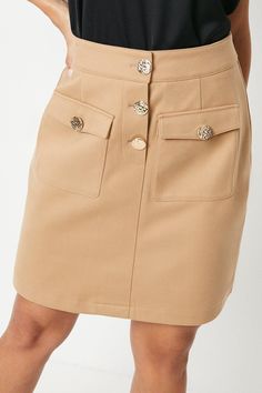 Chic mini skirt with distinctive button detailing
Two functional front patch pockets for added utility
High-waisted design for a flattering silhouette
Textured fabric adds visual interest and depth
Versatile length suitable for various occasions
This Button Detail Mini Skirt from Principles is a smart and sophisticated addition to your wardrobe. The high-waisted design creates a sleek silhouette, while the textured fabric adds a touch of refinement. Style it with a crisp white blouse and black heels for a polished office look, or pair it with a silk camisole and strappy sandals for elegant evening drinks. The functional front pockets offer practicality without compromising on style. For cooler days, layer with opaque tights and ankle boots, topped with a tailored blazer. This versatile p Chic Mini Skirt, Crisp White Blouse, Petite Jumpsuit, Petite Coat, Blouse Sale, Opaque Tights, Silk Camisole, Tall Clothing, Tailored Blazer