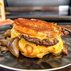 a cheeseburger with onions on a plate