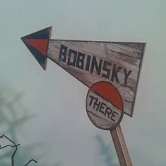 there is a wooden sign that says bodinskiy and there are two arrows