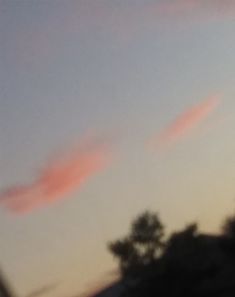 some pink clouds are in the sky at sunset