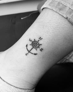 a black and white photo of a person's arm with an anchor tattoo on it