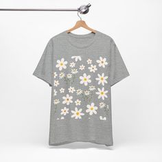 Featuring a breathable cotton fabric that ensures comfort and durability. The intricate daisy meadow design adds a touch of nature-inspired charm. This classic unisex jersey short sleeve tee fits like a well-loved favorite. These soft cotton t-shirts have-ribbed knit collars to bolster shaping. The shoulders are tapered for a better fit over time. Dual side seams hold the garment's shape for longer. .: Made with 100% Airlume combed and ring-spun cotton, a lightweight fabric (4.2 oz/yd² (142 g/m² Casual T-shirt With Daisy Print For Spring, Spring Organic Cotton Relaxed Fit T-shirt, Spring Relaxed Fit Organic Cotton T-shirt, Relaxed Fit Organic Cotton T-shirt For Spring, Spring Organic Cotton T-shirt With Screen Print, Spring Daisy Print Graphic Tee, Summer Daisy Print Short Sleeve T-shirt, White Daisy Print T-shirt For Spring, Spring Daisy Print Relaxed Fit T-shirt