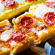 slices of pepperoni pizza sitting on top of a cutting board