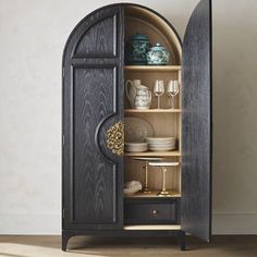 an open cabinet with plates and glasses in it