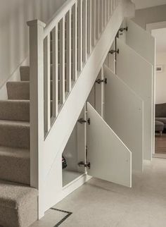 an open door leading up to a stair case in a living room with carpeted flooring