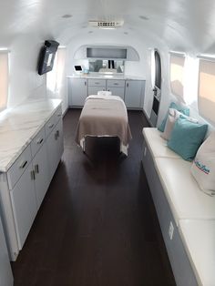 the inside of an airplane with a bed and desks in it, along with other furniture